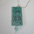 Light turquoise pendant on a chain by textile artist Mary Taylor