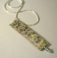 Silver and grey pendant on a chain by textile artist Mary Taylor